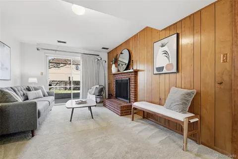 a living room with furniture a fireplace and a large window