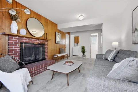 a living room with furniture a fireplace a rug and a window