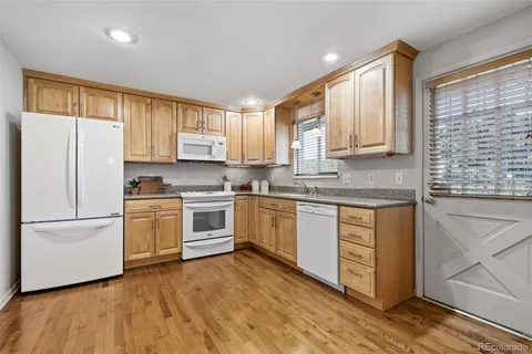 a kitchen with granite countertop white cabinets and white appliances