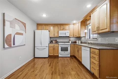 a kitchen with a sink a refrigerator a microwave and cabinets