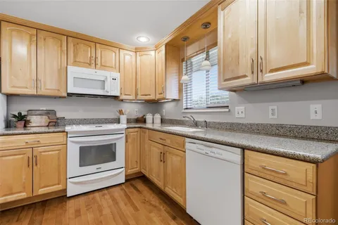 a kitchen with stainless steel appliances granite countertop a sink a stove and cabinets