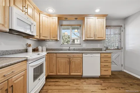 a kitchen with stainless steel appliances granite countertop a sink a stove and cabinets