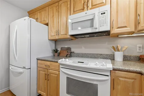 a kitchen with stainless steel appliances granite countertop a refrigerator and a stove