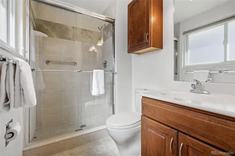 a bathroom with a granite countertop sink toilet and shower