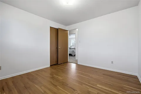 a view of an empty room with wooden floor