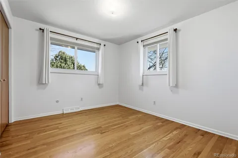 an empty room with a window and wooden floor