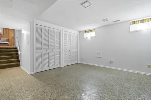 an empty room with kitchen garage and window