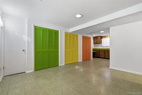 an empty room with stainless steel appliances wooden cabinet and view living room