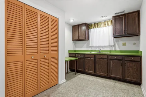 a room with a sink cabinets and a window