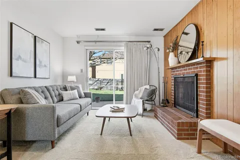 a living room with furniture a fireplace and a large window
