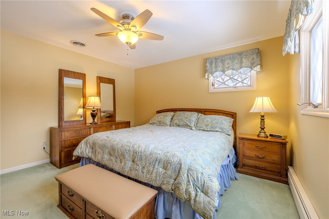 535 Barrington Ridge Road Painesville, OH 44077 - Photo 40 of 48 Carpeted bedroom featuring multiple windows, ceiling fan, and baseboard heating