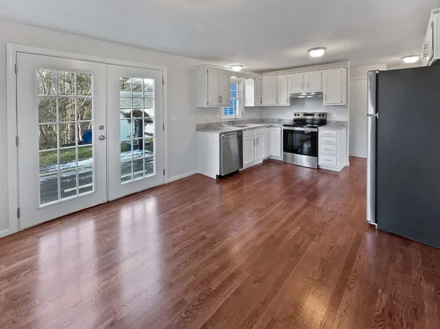 a view of kitchen with wooden floor and electronic appliances