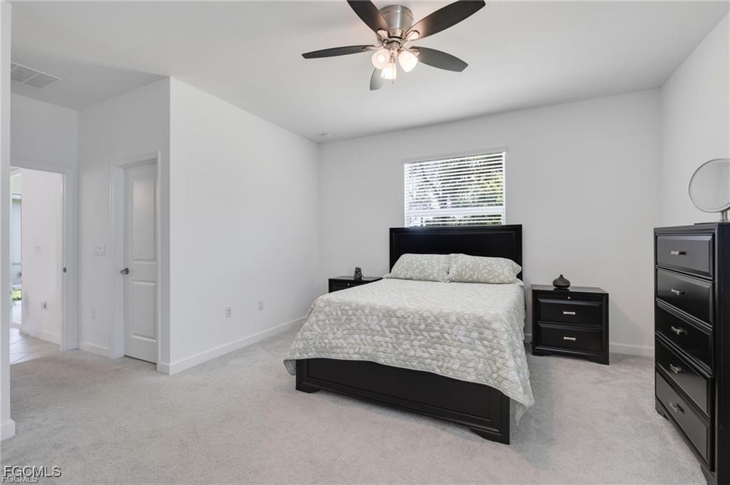 9146 Leatherwood Loop Lehigh Acres, FL 33936 - Photo 19 of 43 a bedroom with a bed and a view of closet