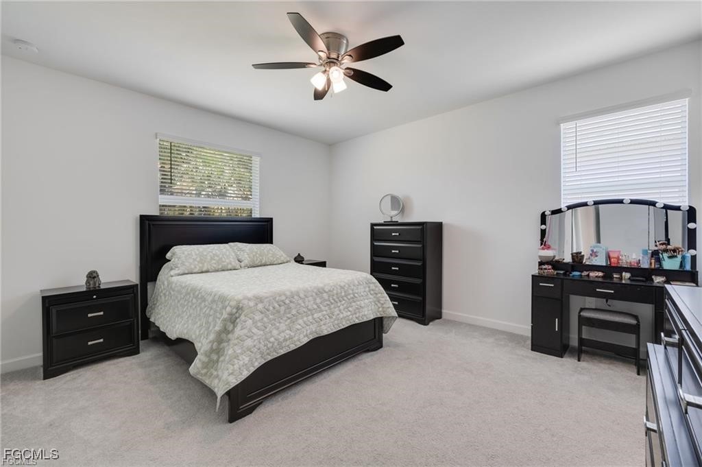 9146 Leatherwood Loop Lehigh Acres, FL 33936 - Photo 20 of 43 a bedroom with a bed and a chandelier