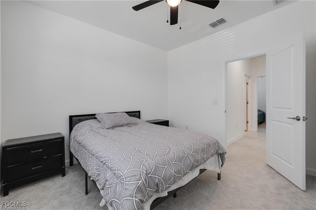 9146 Leatherwood Loop Lehigh Acres, FL 33936 - Photo 25 of 43 a bedroom with a bed and a ceiling fan