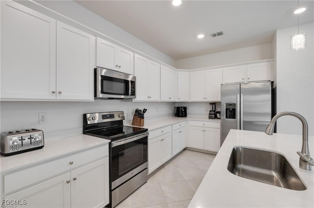 9146 Leatherwood Loop Lehigh Acres, FL 33936 - Photo 8 of 43 a kitchen with granite countertop white cabinets and stainless steel appliances