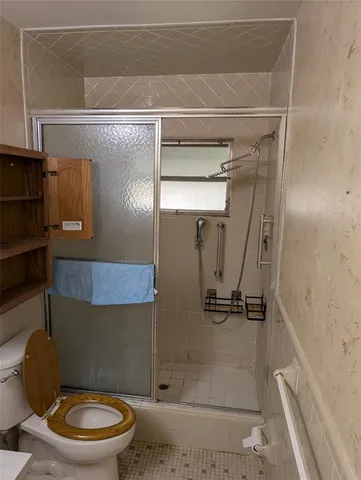 a bathroom with a toilet and a shower