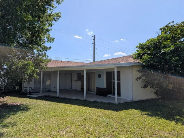 a view of a house with a yard and potted plants