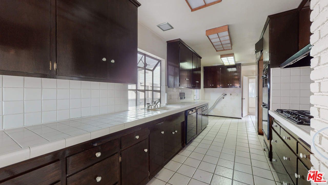 2254 Stradella Road Los Angeles, CA 90077 - Photo 13 of 29 a kitchen with stainless steel appliances a sink stove and cabinets