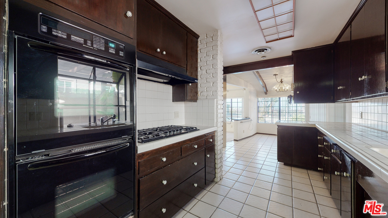 2254 Stradella Road Los Angeles, CA 90077 - Photo 14 of 29 a kitchen with stainless steel appliances granite countertop a stove and a wooden cabinets