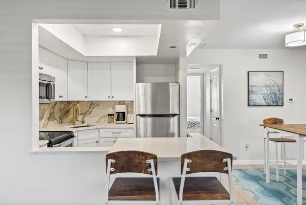 a view of washer and dryer with kitchen in the background
