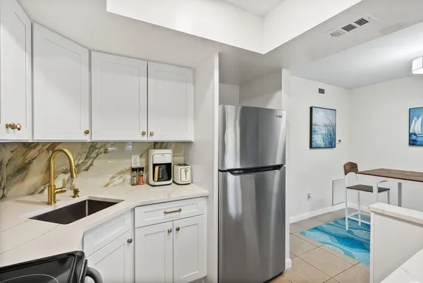 a kitchen with appliances a sink and cabinets