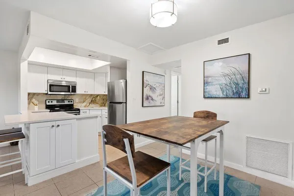 a kitchen with a refrigerator a stove top oven a counter space and a window