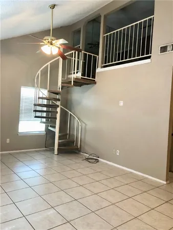 a view of a livingroom with wooden floor and stairs