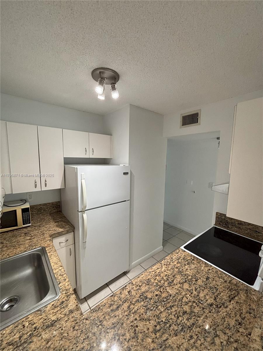 126 Southwest 17th Road, Unit 505 Miami, FL 33129 - Photo 17 of 23 a kitchen with a refrigerator sink and cabinets