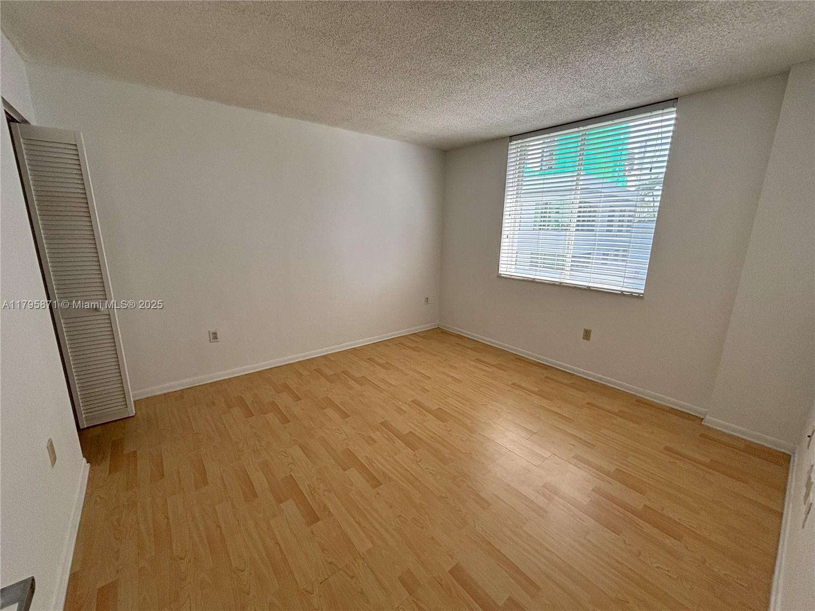 126 Southwest 17th Road, Unit 505 Miami, FL 33129 - Photo 4 of 23 a view of an empty room with wooden floor and a window