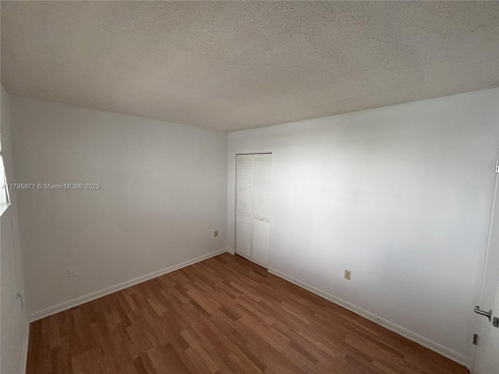 126 Southwest 17th Road, Unit 505 Miami, FL 33129 - Photo 9 of 23 an empty room with wooden floor and windows