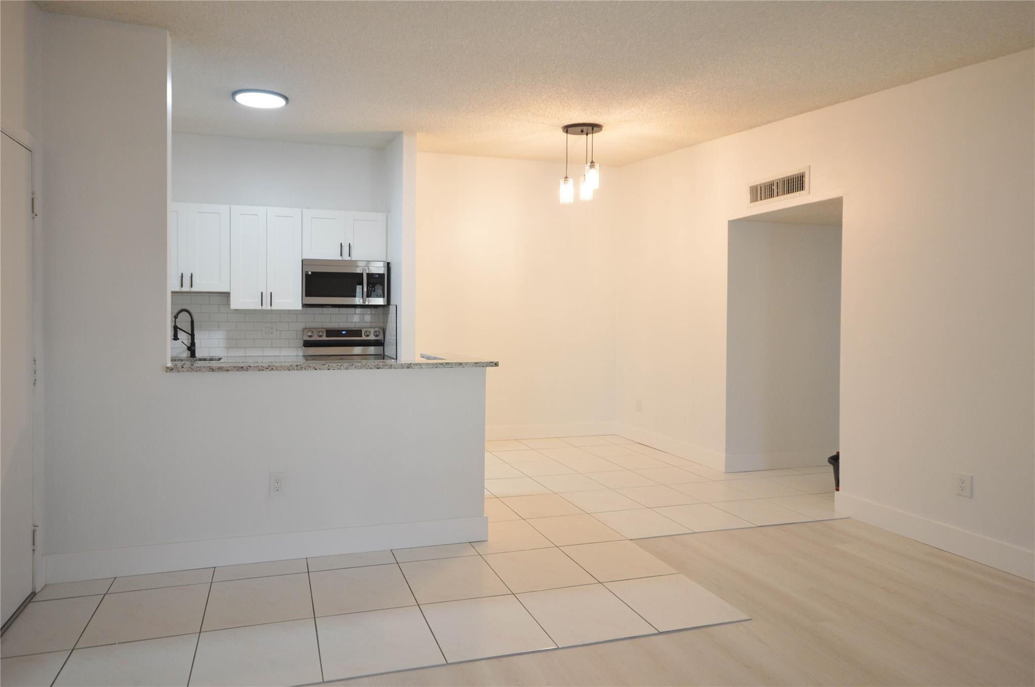 9499 West McNab Road, Unit 208 Tamarac, FL 33321 - Photo 4 of 19 a kitchen with stainless steel appliances a refrigerator sink and microwave