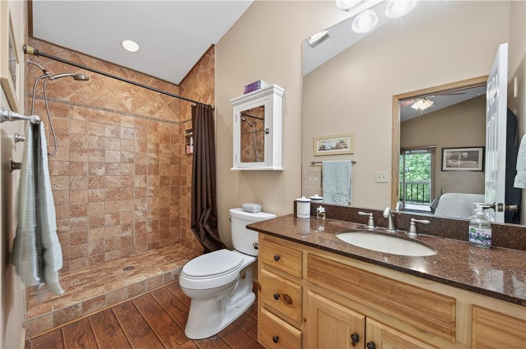 200 Bahn Innsbruck Helen, GA 30545 - Photo 21 of 84 a bathroom with a granite countertop sink toilet a large mirror a shower and bathtub