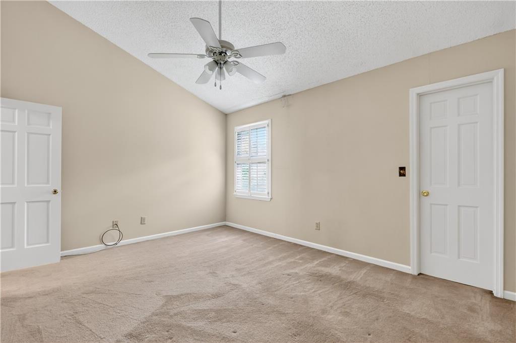 2197 Spring Walk Court Atlanta, GA 30341 - Photo 22 of 31 an empty room with a chandelier fan and windows