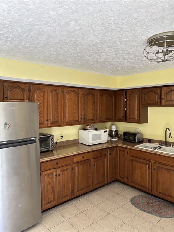 283 Fuller Road, Unit T Chicopee, MA 01020 - Photo 5 of 12 a kitchen with a sink and cabinets