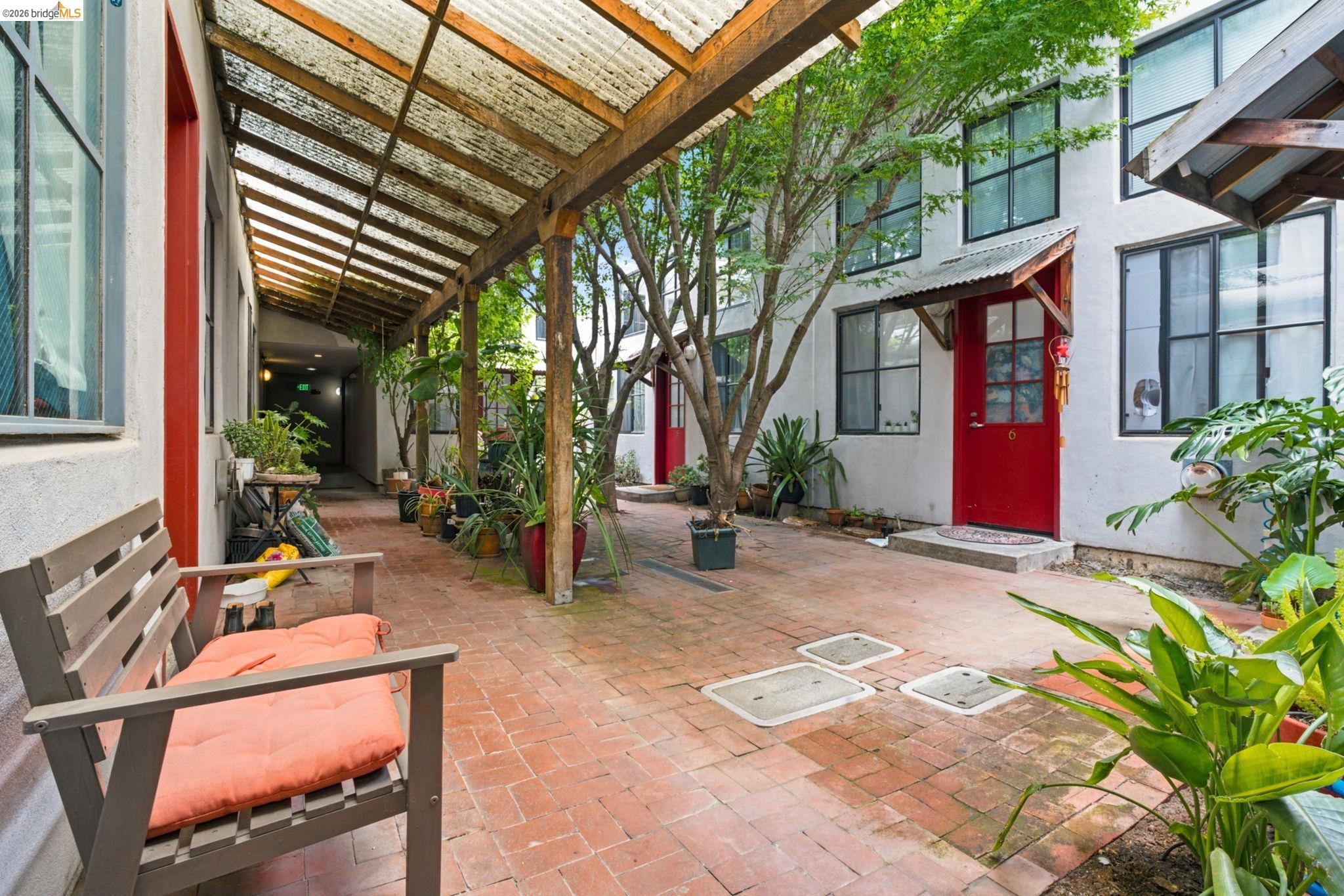 1920 Union Street, Unit 9 Oakland, CA 94607 - Photo 33 of 35 Brick paver courtyard featuring multiple entryways with red doors