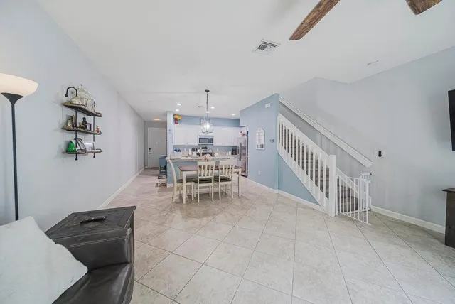 a living room with furniture and a dining table with white walls