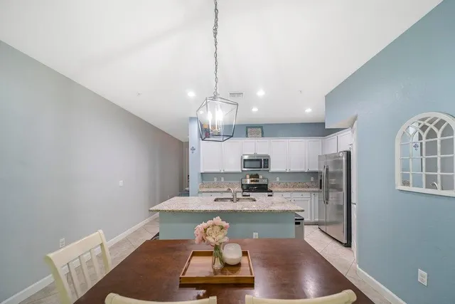 a view of a kitchen with a sink dishwasher a fireplace with a dining table and chairs