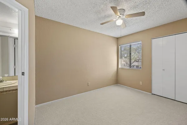 an empty room with a bathroom and a ceiling fan