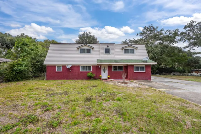 a view of a house with a yard patio and fire pit