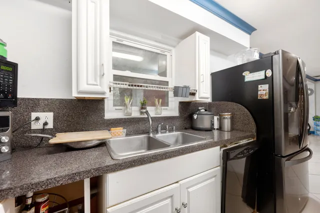 a kitchen with granite countertop a sink stainless steel appliances and cabinets