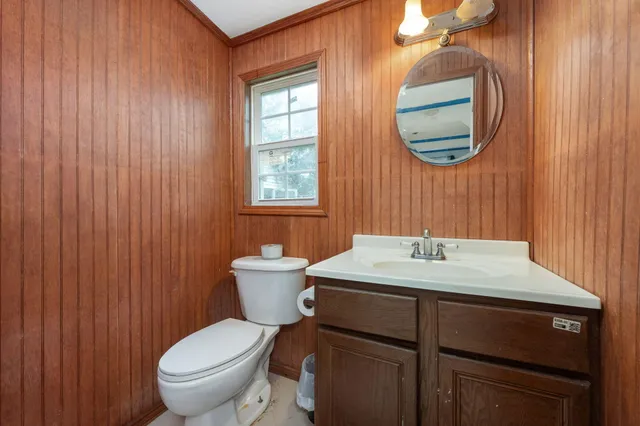 a bathroom with a toilet a sink and mirror