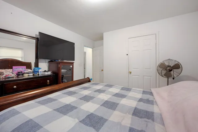 a bedroom with a bed and a flat screen tv