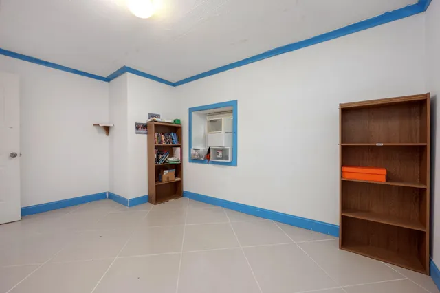 a view of an empty room with closet and a window