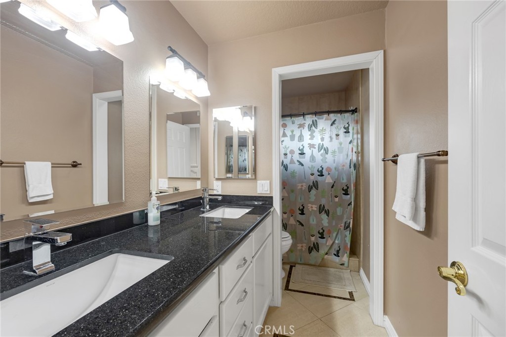 2611 Rudy Street Rowland Heights, CA 91748 - Photo 29 of 37 a bathroom with a granite countertop sink a toilet a mirror and shower