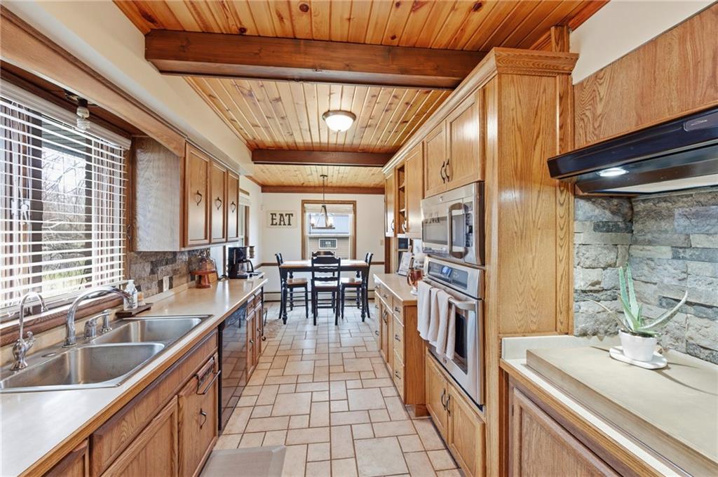 942 Cleland Mill Road New Castle, PA 16102 - Photo 12 of 41 a kitchen with stainless steel appliances granite countertop a sink and wooden cabinets