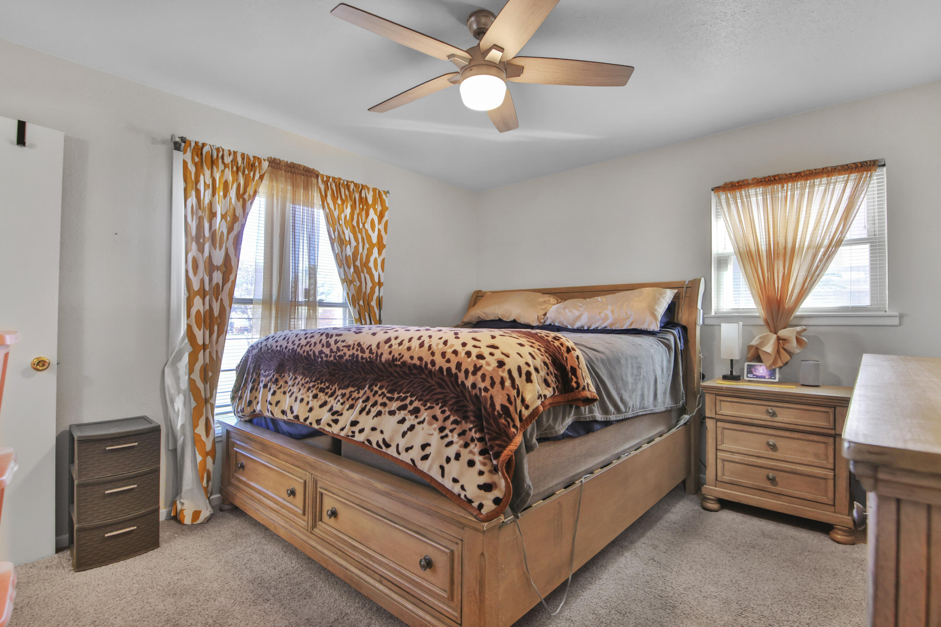 5625 Amherst Street Lubbock, TX 79416 - Photo 18 of 32 a bedroom with a bed and a chandelier