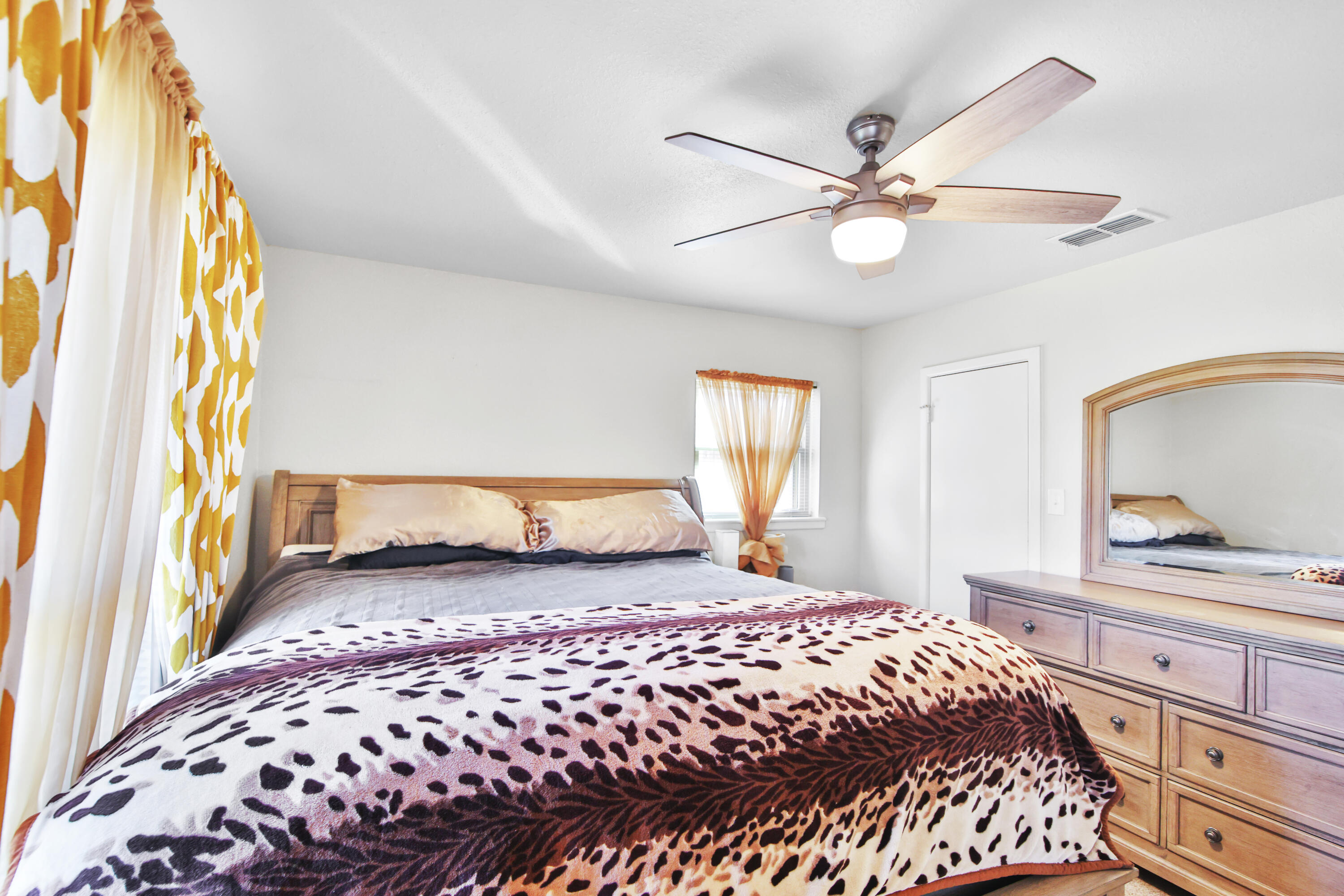 5625 Amherst Street Lubbock, TX 79416 - Photo 20 of 32 a bedroom with a large bed and a chandelier