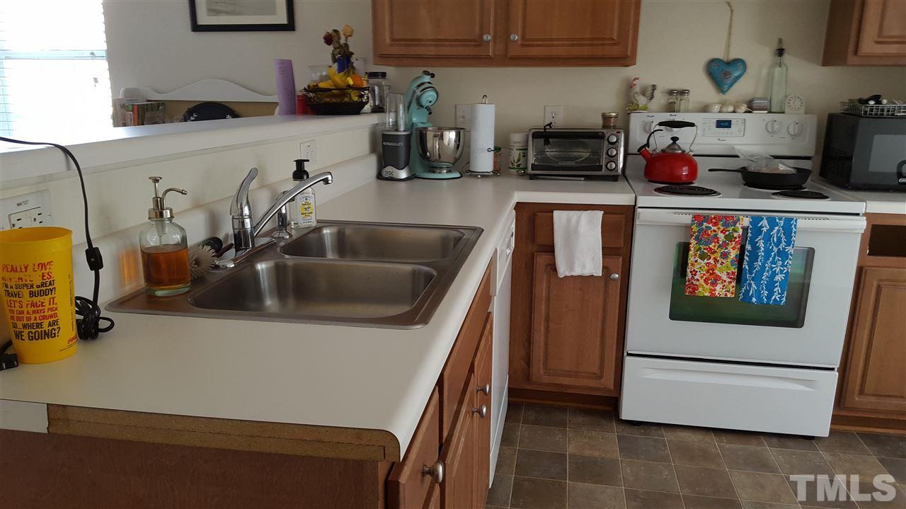 4806 Kitledge Drive Raleigh, NC 27610 - Photo 15 of 24 a kitchen with stainless steel appliances granite countertop a sink and a refrigerator