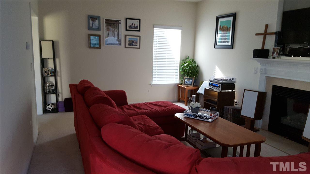 4806 Kitledge Drive Raleigh, NC 27610 - Photo 4 of 24 a living room with furniture a flat screen tv and a fireplace